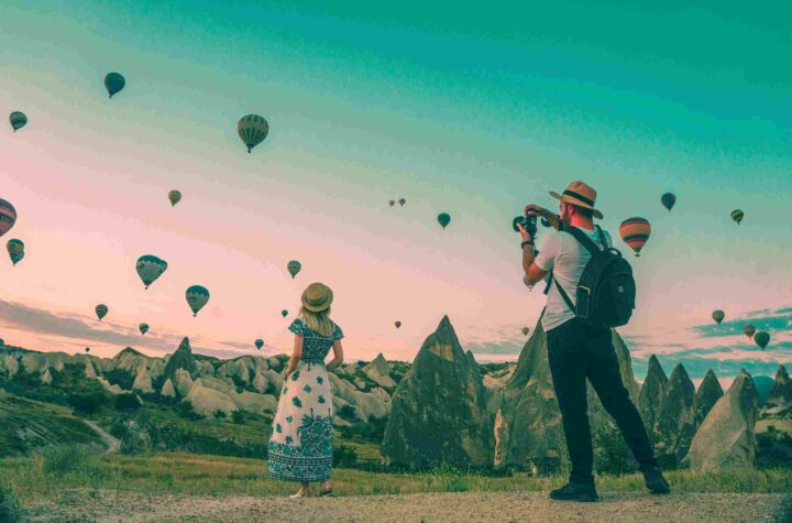 tourists on vacation looking at hot air balloons