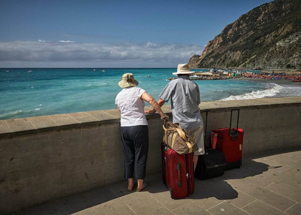 couple on vacation stands with their luggage